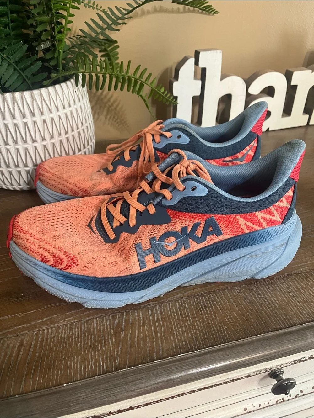 HOKA Women's Challenger ATR 7 sneakers feature a vibrant papaya orange mesh